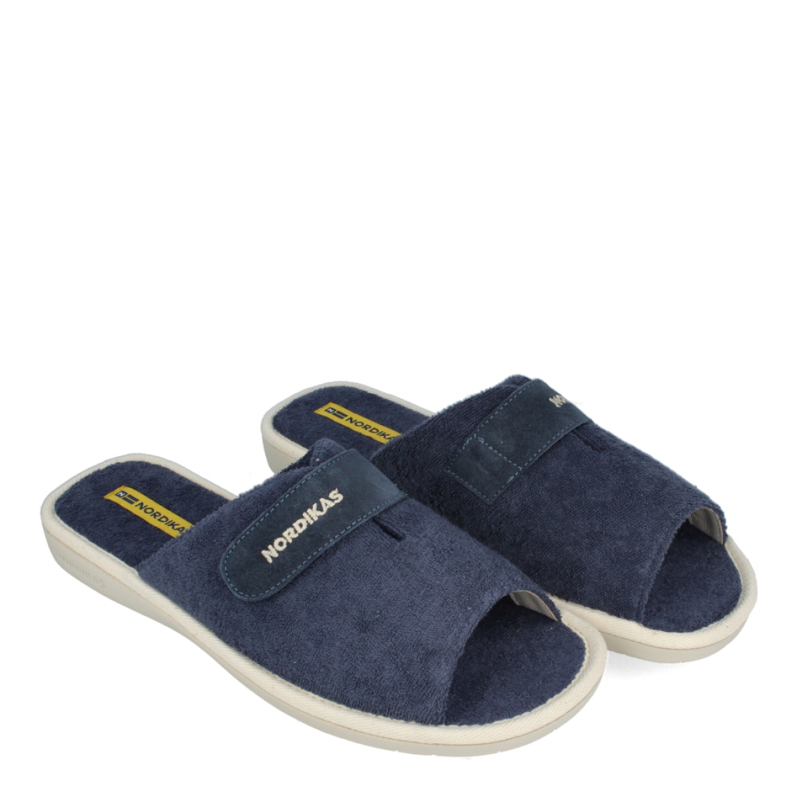 Zapatillas de la marca Nordikas, modelo TOP LINE. Exterior e interior de las zapatillas en toalla color azul. Cierre de las zapatillas con velcro y suela de goma plana. Estas zapatillas Nordikas TOP LINE, te hará disfrutar de la comodidad y ligereza de estar por casa.