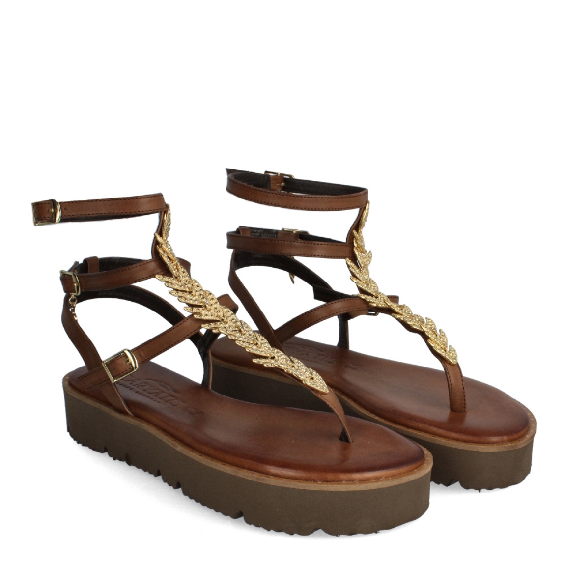 Sandalias de la marca Caryatis, modelo GOYA. Exterior de las sandalias en piel color marrón con detalles en metal dorado en forma de hojas en la pala. Cierre de las sandalias con triple hebilla. Estas sandalias Caryatis GOYA, tiene un estilo elegante e innovador, que te hará crear diferentes looks elegantes y originales. No puede faltar en tu armario de temporada.