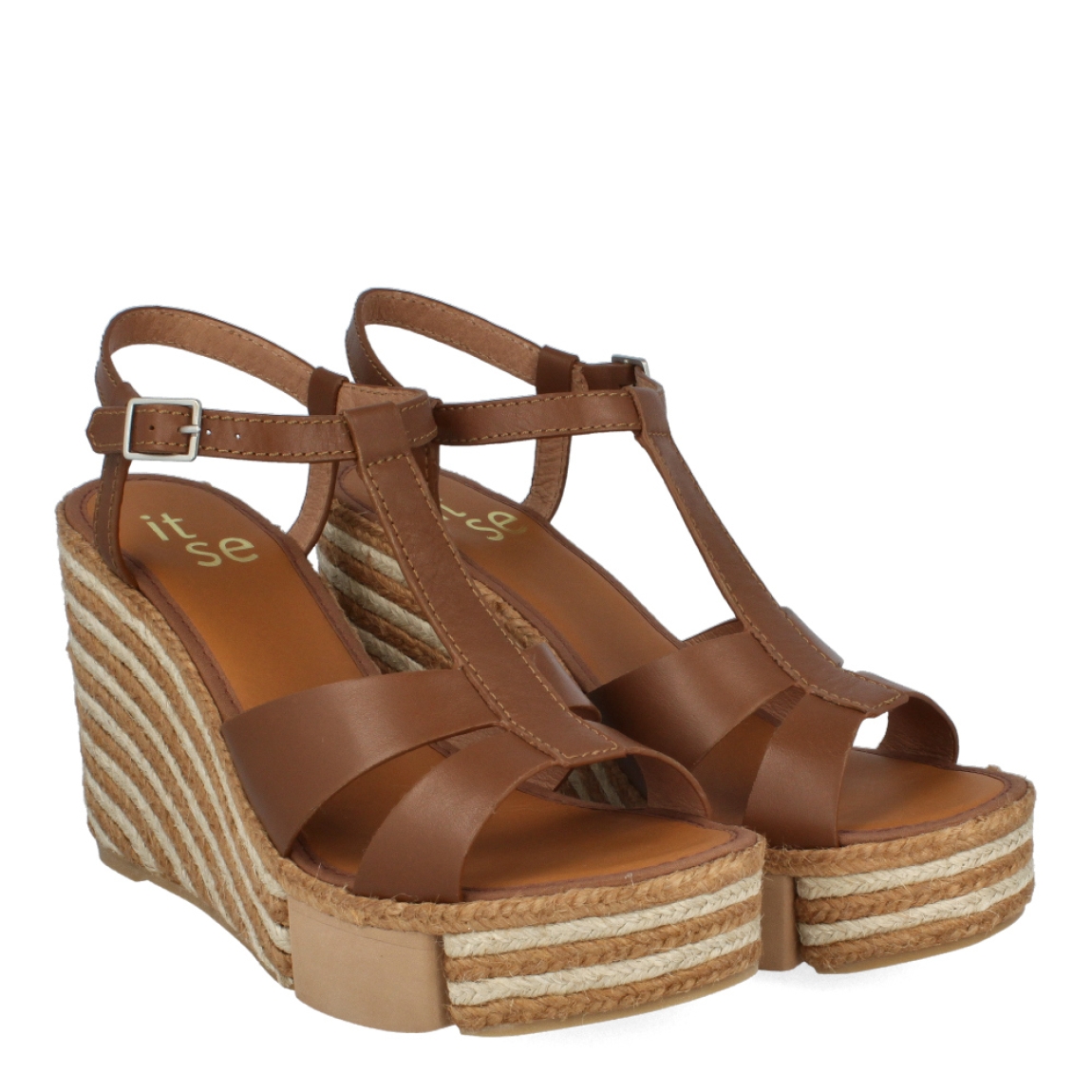 Sandalias de la marca Casteller, modelo BRUNA. Exterior e interior de las sandalias en piel color marrón. Cierre de las sandalias con hebilla en el tobillo. Sandalias Casteller con cuña de 10cm de altura con diseño de ondas. Estas sandalias Casteller BRUNA son unas clásicas para temporada, podrás crear diferentes looks con la máxima comodidad posible.
