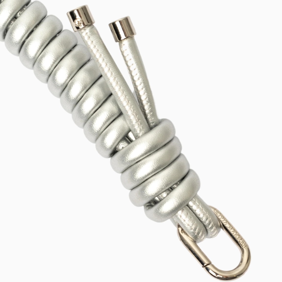 Cadena para bolso de la marca Olivia Mareque, elaborada en piel con efecto rizada color plata. Acabada con dos mosquetones. Personalizada con logo. Medida de 60cm. Complemento compatible con cualquier bolso.