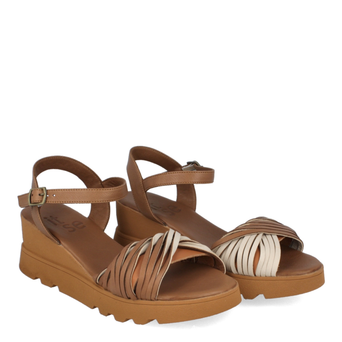 Sandalias de la marca Itse, modelo GEMA. Exterior de las sandalias en piel color taupe con pala cruzada en tiras. Interior de las sandalias en piel color taupe. Cierre de las sandalias Itse con hebilla y cuña de 5cm de altura. Estas sandalias Itse GEMA son el complemento ideal para tus looks de temporada. No te puede faltar en el armario.