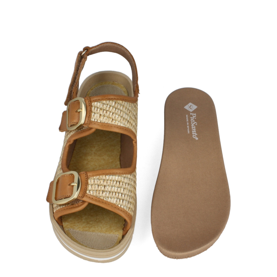 Sandalias de la marca PieSanto, modelo SHAROM. Exterior de las sandalias en rafia trenzada color camel. Interior de las sandalias en piel color camel con plantilla acolchada y extraíble. Ciere de las sandalias PieSanto con doble hebilla en pala y empeine, y velcro en el talón. Sandalias con cuña de 3cm de altura. Estas sandalias PieSanto SHAROM son el complemento ideal para tus looks de temporada, podrás crear diferentes outfits con la máxima comodidad.