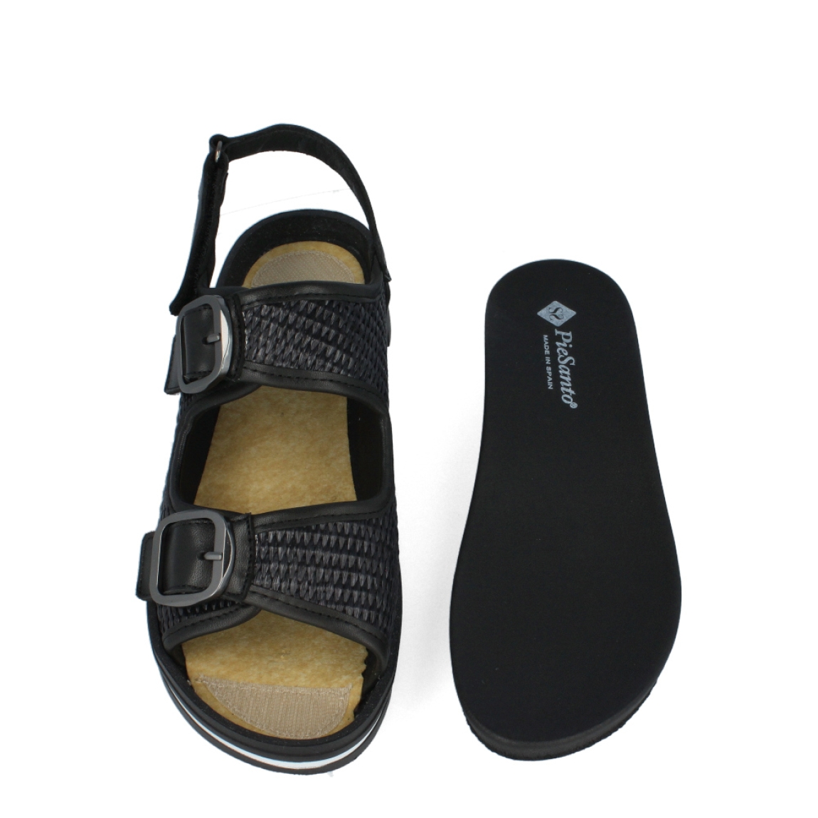 Sandalias de la marca PieSanto, modelo SHAROM. Exterior de las sandalias en rafia trenzada color negro. Interior de las sandalias en piel color negro con plantilla acolchada y extraíble. Cierre de las sandalias PieSanto con doble hebilla en empeine y pala, y velcro en el talón. Sandalias con cuña de 3cm de altura. Estas sandalias PieSanto son el complemento perfecto de temporada, podrás crear diferentes outfits con la máxima comodidad.