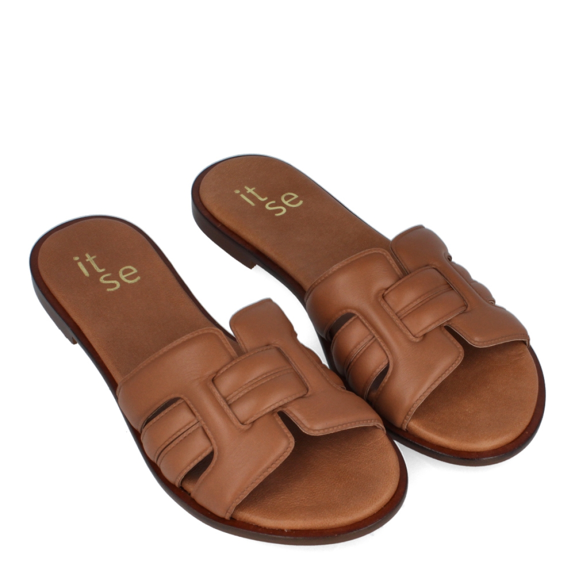 Chanclas de la marca Itse, modelo CORINA. Exterior de las chanclas en piel color marrón con pala Hermes. Interior de las chanclas en piel colro camel. Chanclas Itse con suela plana de goma. Estas chanclas Itse CORINA son un complemento básico para tus looks de temporada. No te puede faltar en el armario.