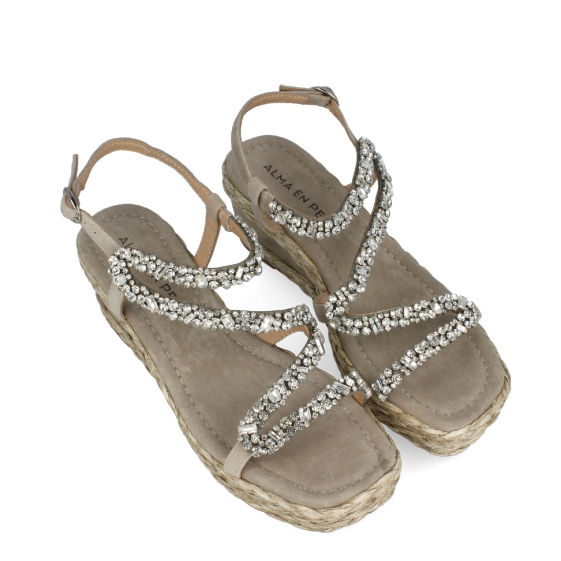 Sandalias de la marca Alma en Pena, modelo BRILLE. Exterior de las sandalias en ante color taupe con tiras brillantes. Interior de las sandalias en ante colr taupe. Cierre de las sandalias Alma en Pena con hebilla y cuña de 6cm de altura. Estas sandalias Alma en Pena BRILLE tienen el diseño que necesitas para destacar tus looks con elegancia y comodidad. No puede faltar en el armario.