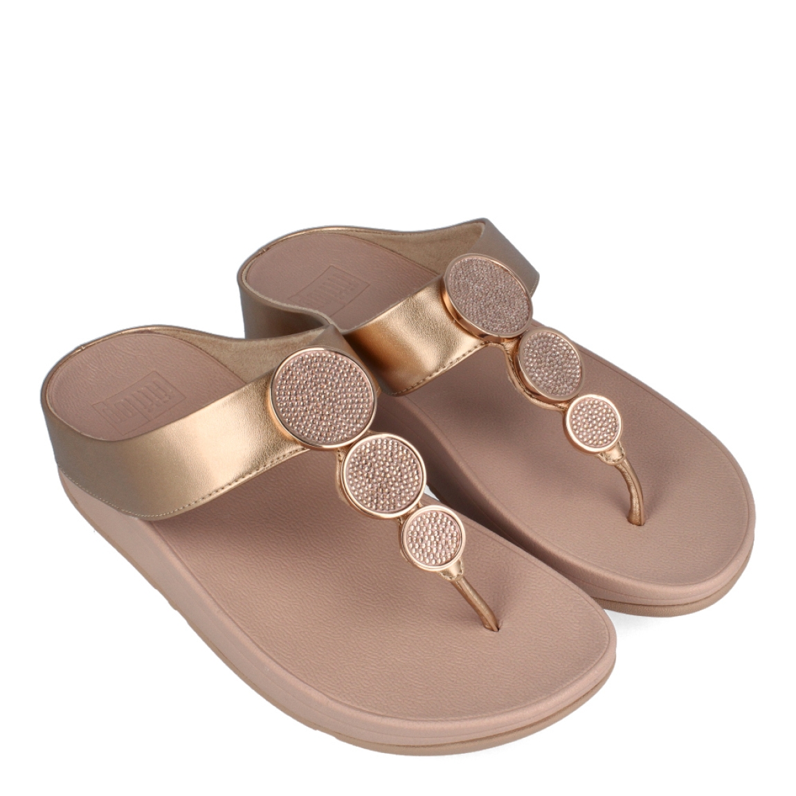 Esclavas de la marca Fitflop, modelo HALO. Esclavas elaboradas en piel color nude con detalle de círculos dorados brillantes en la pala. Esclava Fitflop con cuña de 4cm de altura. Estas esclavas Fitflop HALO son un complemento básico para esta temporada, disfrutarás de una comodidad excepcional en tu día a día.