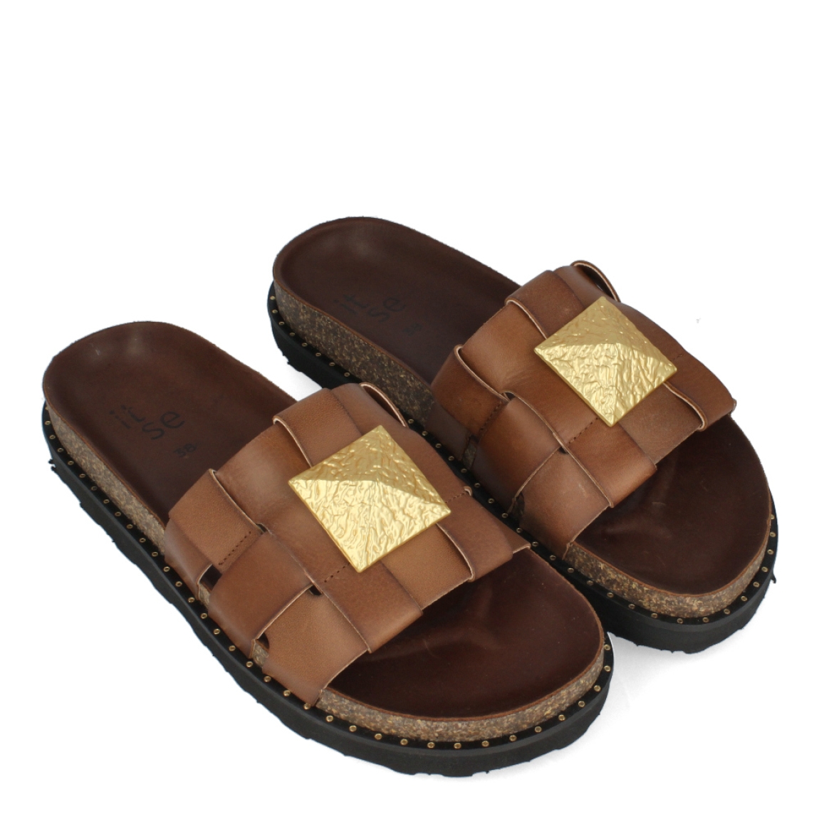 Chanclas de la marca Itse, modelo CLEO. Chanclas elaboradas en piel color cuero con detalle de pirámide en la pala. Chanclas con suela plana. Las chanclas Itse CLEO son un complemento ideal para disfrutar de la comodidad máxima en tu día a día durante esta temporada.