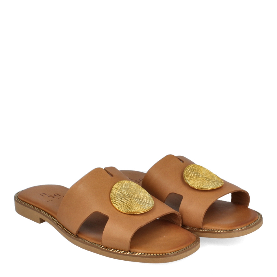 Chanclas de la marca Itse, modelo TALIA. Chanclas elaboradas en piel color cuero con detalle de círculo metal dorado en la pala. Chanclas con suela plana. Estas chanclas Itse TALIA son un complemento ideal para gozar de la máxima comodidad en tu día a día. No te puede faltar en el armario.