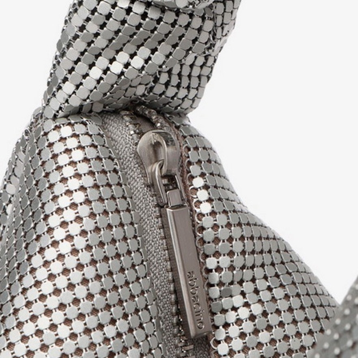 Bolso de la marca Abbacino, modelo LUCY. Bolso elaborado con malla metálica color plata. Interior en forro textil. Cierre del bolso con cremallera. Bolso Binnari con asa de mano drapeada y una práctica bandolera de cadena de quita y pon. Medidas del bolso: alto 12cm y ancho 24cm. Este bolso Binnari LUCY es un complemento ideal para lucir tus looks de día y noche.