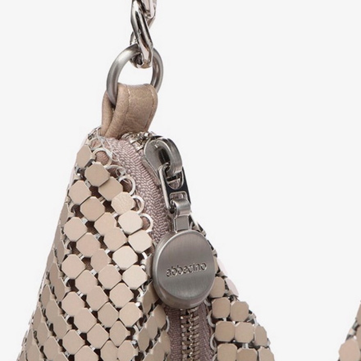 Bolso de la marca Abbacino, modelo EVA. Bolso elaborado en malla metálica color taupe. Interior con forro textil con compartimentos organizadores. Cierre del bolso con cremallera y asa de hombro en cadena multicolor. Medidas del bolso: alto 24cm y ancho 28cm. Este bolso Abbacino EVA es un complemento ideal para tus looks de día y noche. Te ayudarán a resaltar vayas donde vayas.