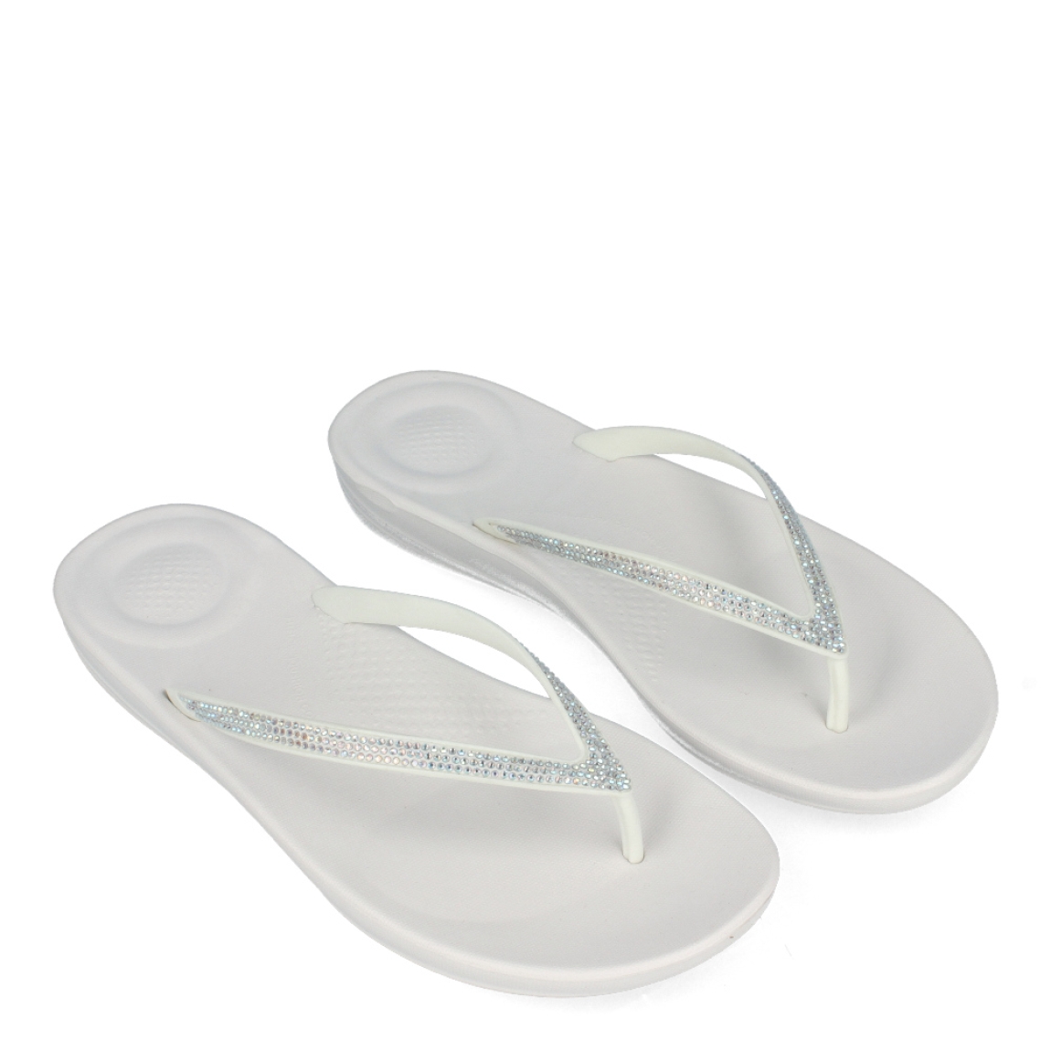 Esclavas de la marca Fitflop, modeo IQUSHIO. Esclavas elaboradas en neopreno color blanco con detalle en brillantes y suela plana. Estas esclavas Fitflop IQUSHIO son unas clásicas para esta temporada, podrás combinarlas con todos tus looks veraniegos y gozar de una comodidad máxima.