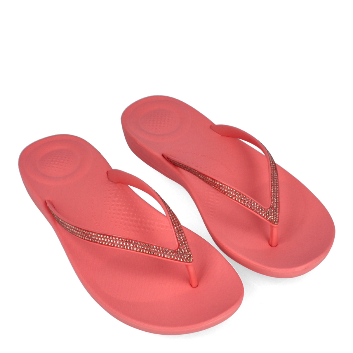 Esclavas de la marca Fitflop, modelo IQUSHIO. Esclavas elaboradas en neorpreno color coral con detalle en brillantes y suela plana. Estas esclavas Fitflop IQUSHIO son unas clásicas para esta temporada, podrás combinarlas con todos tus looks veraniegos y gozar de una comodidad máxima.