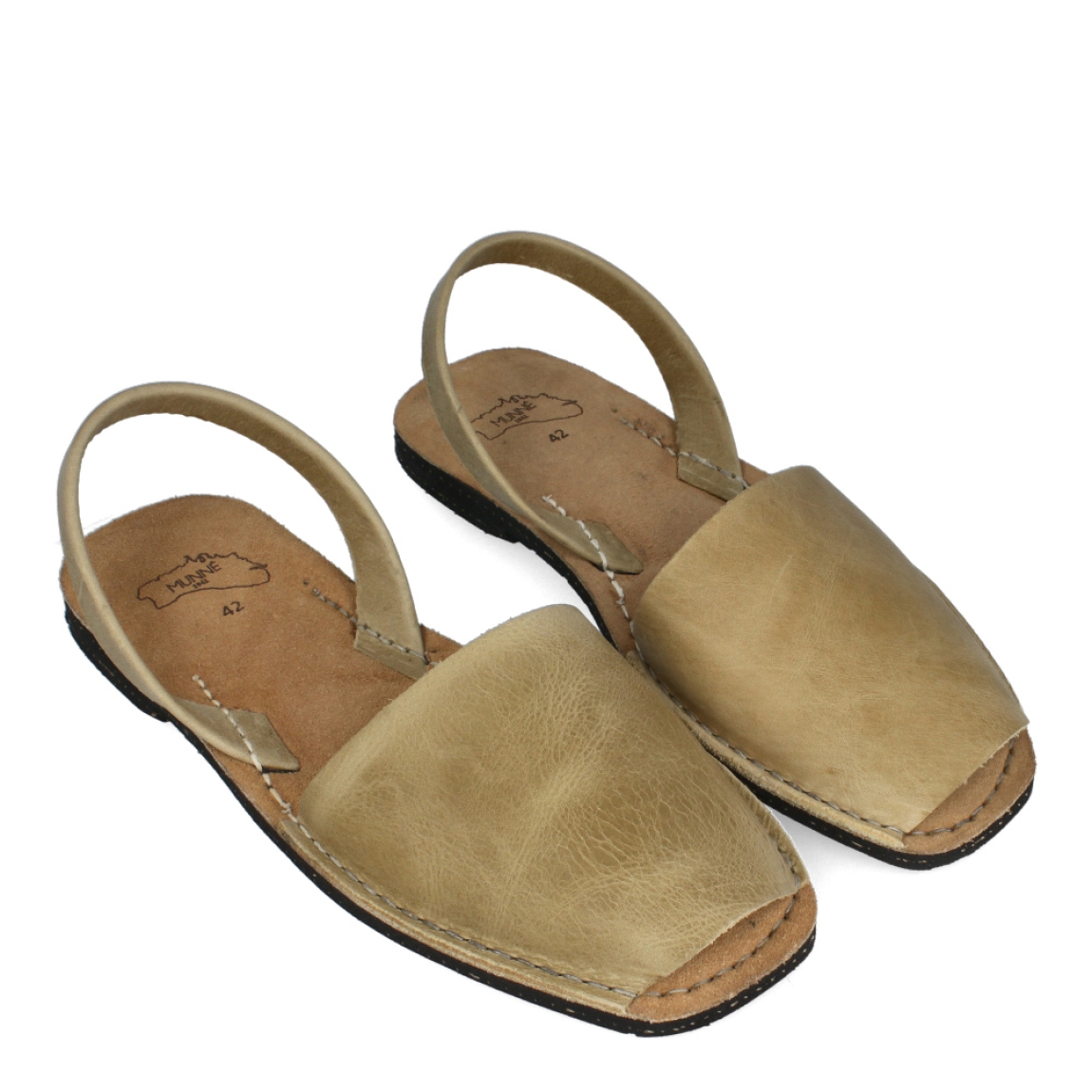 Albarca de la marca Munné, modelo MENORCA. Albarcas claásicas elaboradas en piel color taupe con plantilla acolchada y suela plana. Estas albarcas Munné MENORCA son un complemento ideal para combinar tus looks de temporada y disfrutar de una comodidad máxima.