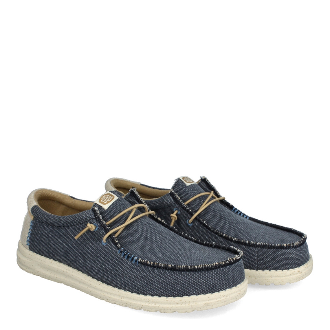 Náuticos clásicos de la marca HeyDude, modelo HD40. Exterior de los náuticos en tela color azul. Interior en tela colro camel. Cierre de los náuticos hd40 con cordón elástico y suela plana. Estos náuticos HeyDude HD40 son un complemento esencial de temporada, que no te puede faltar en el armario.