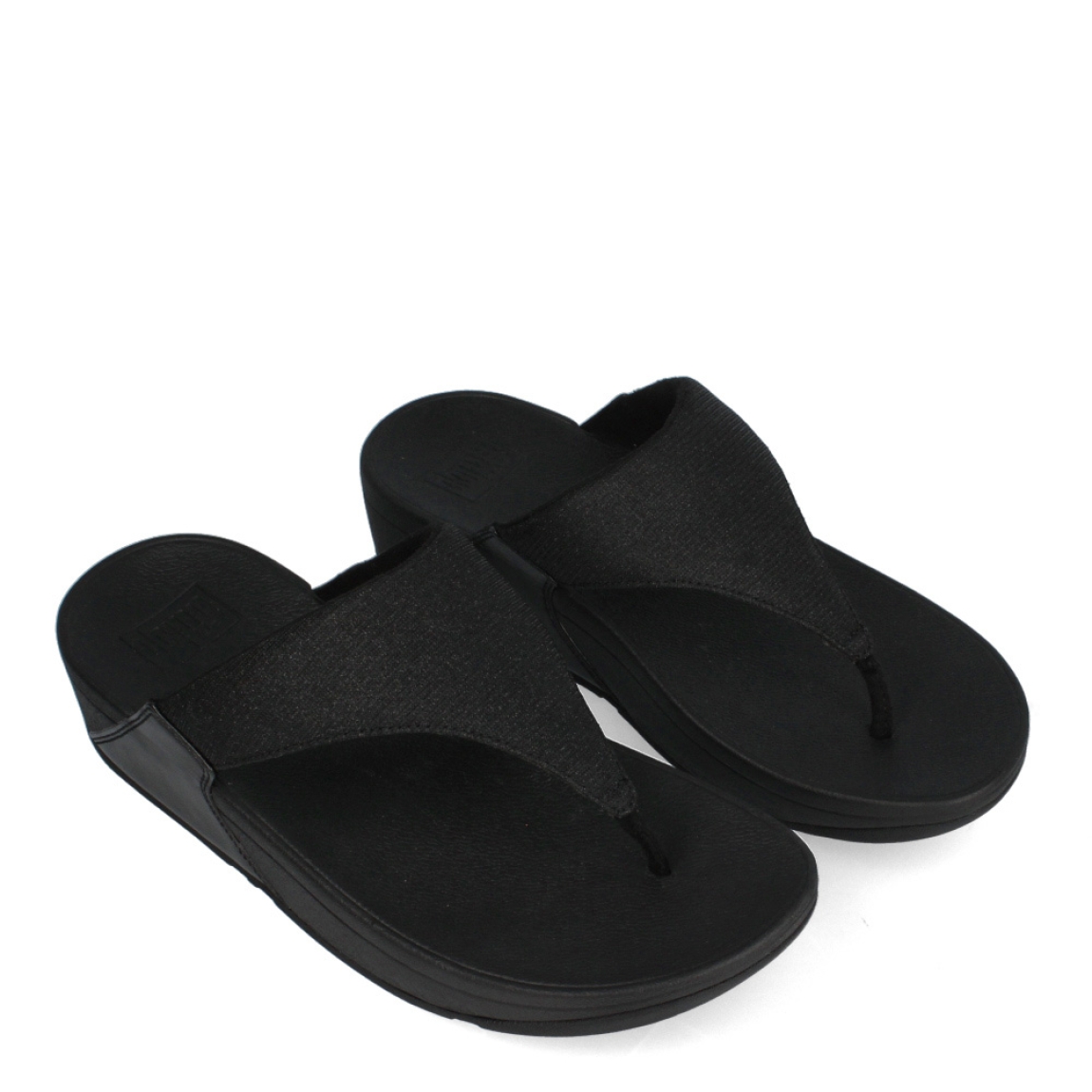Esclavas de la marca Fitflop, modelo LULU. Exterior de las esclavas en neopreno color negro con glitter en la pala. Esclavas con suela de goma y cuña de 3cm de altura. Estas esclavas Fitflop LULU son un complemento clásico para esta temporada, podrás disfrutar de una comodidad en tus looks del día a día.