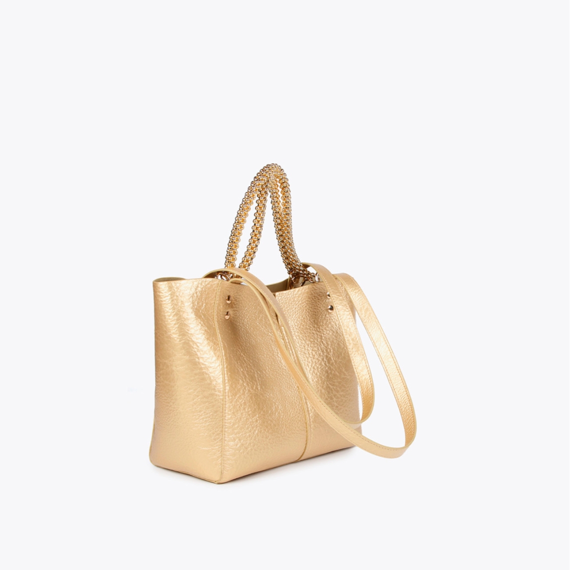 Bolso mediano de la marca Lola Casademunt, modelo LEA. Bolso en efecto piel metalizado color platino con asa metálica decorativa. Contiene pouch interior. Cierre imantado.ALTO: 23 cm - LARGO: 27 cm - ANCHO: 11 cm / BANDOLERA: 58 cm