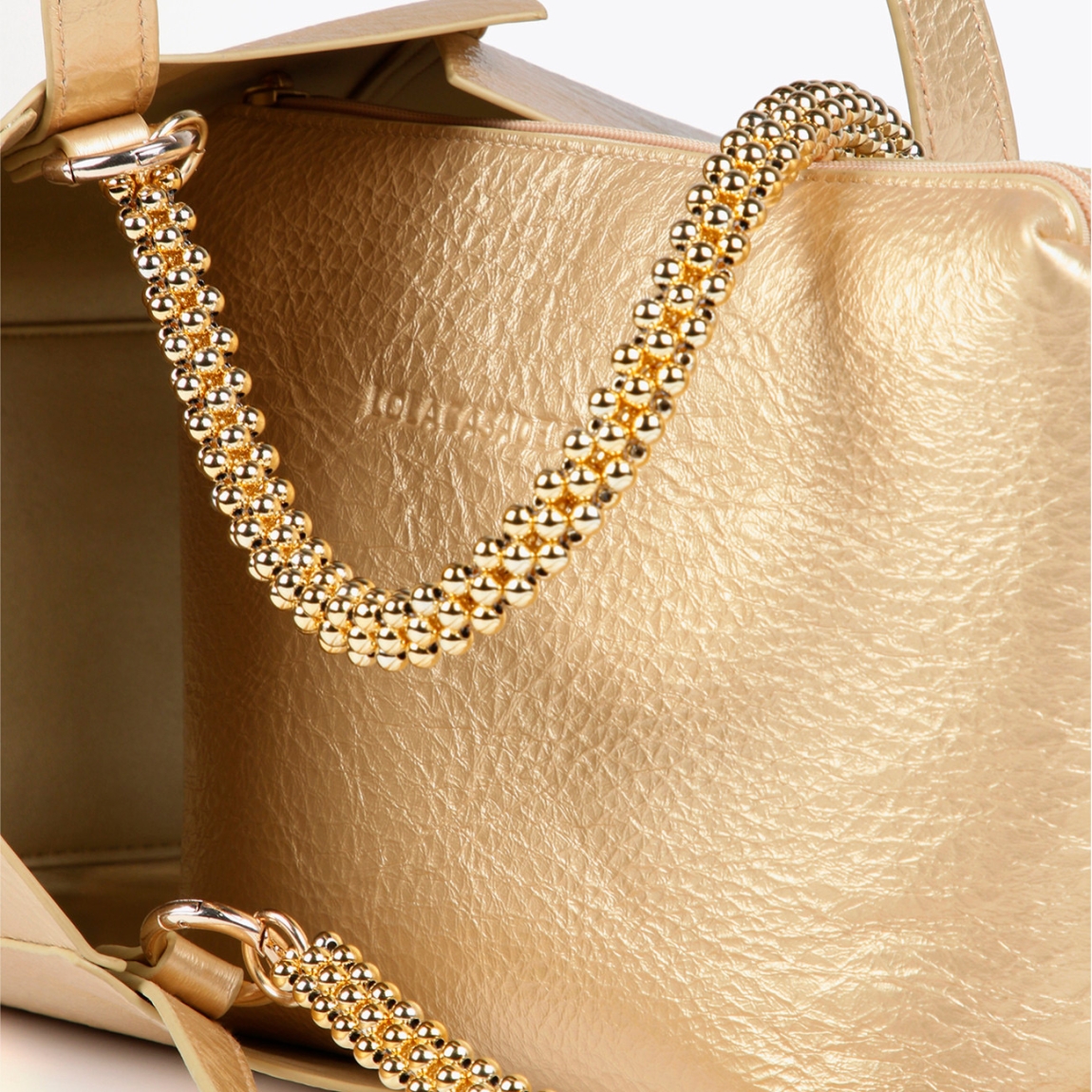 Bolso mediano de la marca Lola Casademunt, modelo LEA. Bolso en efecto piel metalizado color platino con asa metálica decorativa. Contiene pouch interior. Cierre imantado.ALTO: 23 cm - LARGO: 27 cm - ANCHO: 11 cm / BANDOLERA: 58 cm