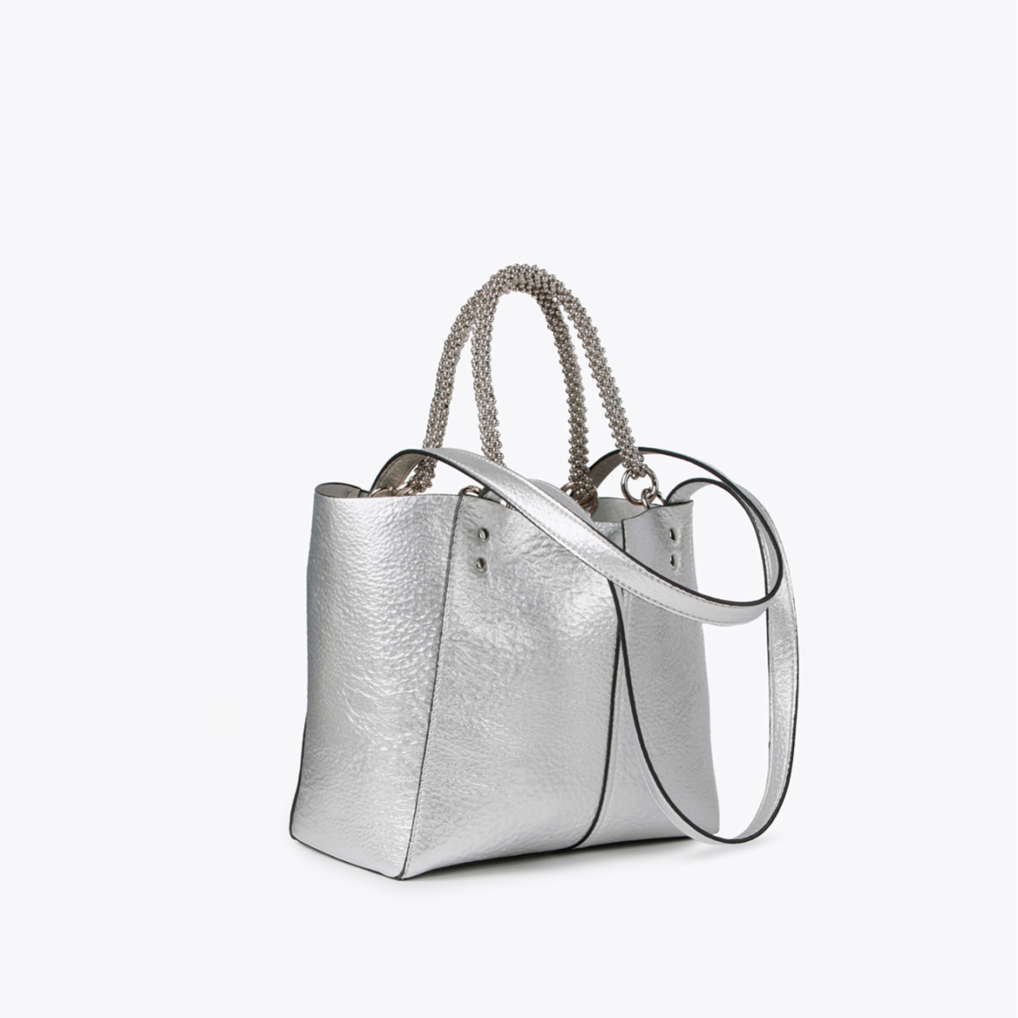 Bolso mediano de la marca Lola Casademunt, modelo LEA. Bolso en efecto piel metalizado color plata con asa metálica decorativa. Contiene pouch interior. Cierre imantado.ALTO: 23 cm - LARGO: 27 cm - ANCHO: 11 cm / BANDOLERA: 58 cm