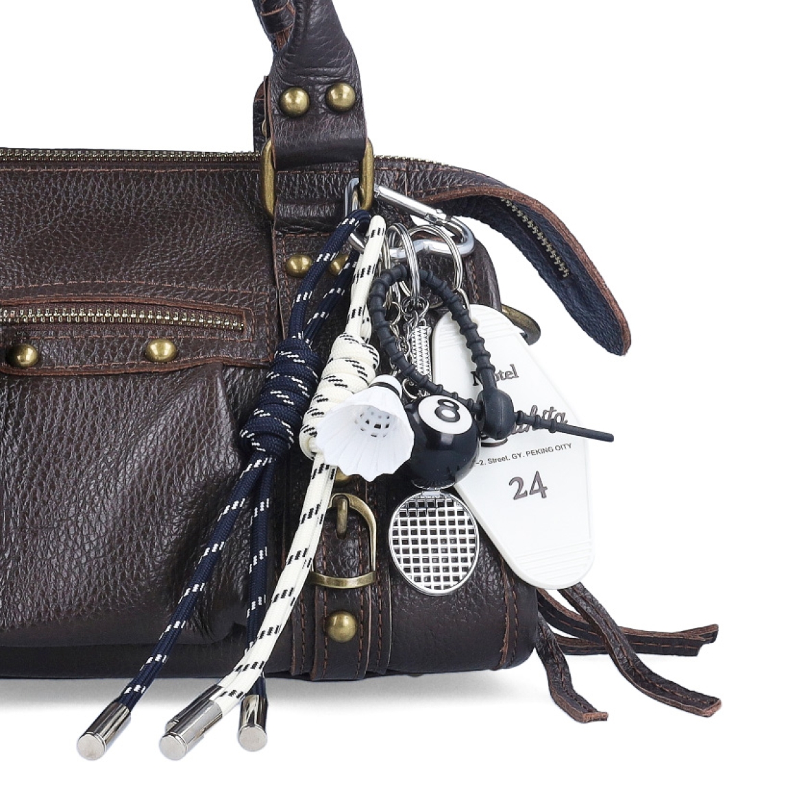 LLavero de la marca Munné, modelo BOL. Elaborado en tela color negro con charms de bádminton. Complemento ideal para combinarlo con tus bolsos.