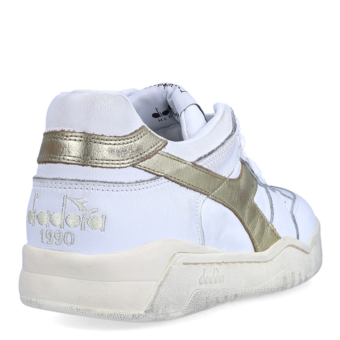 Deportivas de la marca Diadora, modelo B560. Exterior en piel troquelada color blanco con detalles en dorado. Interior en textil color blanco, con plantilla acolchada y extraíble para máxima comodidad. Cierre con cordones de color blanco. Suela de goma con cuña de 3cm de altura. Estas deportivas B560 son unas clásicas ideales para llevar en tu día a día.