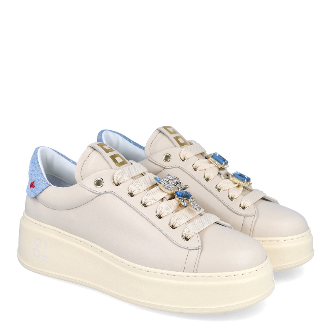 Deportivas de la marca GIO+, modelo PIA. Exterior en piel color beig con detalle de brillantes color celeste en el talón. Interior en piel blanca con plantilla acolchada y extraíble para máxima comodidad. Cierre de las deportivas con cordones, y adornos en forma de gato con piedreria azul sobre la pala. Plataforma de 4cm de altura. Estas deportivas GIO+ PIA son las clásicas con el toque de estilo moderno que necesitas en tus looks de temporada!