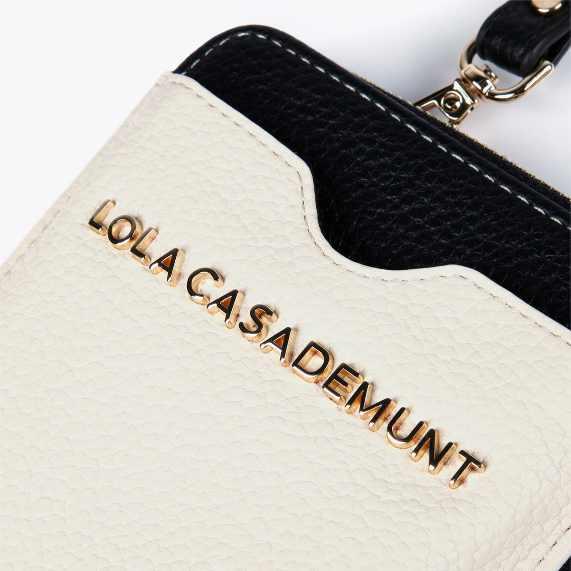 Funda clasica de la marca Lola Casademunt, modelo CLOE. Mini bolso porta móvil bicolor en efecto piel color beig. Contiene distintos compartimentos para billetes y tarjetas y asa bandolera ajustable. Cierre con cremallera.ALTO: 18,5 cm - LARGO: 12 cm - ANCHO: 3,3 cm / BANDOLERA: 141 cm