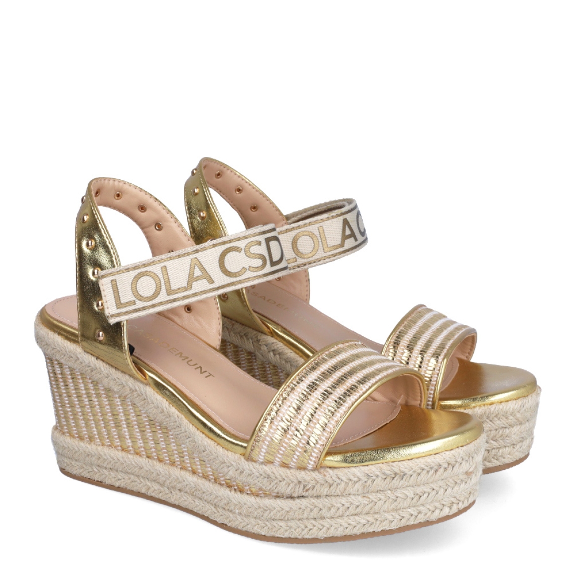 Sandalias de la marca Lola Casademunt, modelo INTI. Exterior en piel color platino con detalle de tachuelas. Interior en piel color beig. Cierre con velcro con estampado de marca. Sandalias con cuña de 9cm de altura. Estas sandalias Lola Casademunt INTI son un complemento que le dará estilo a tus looks!
