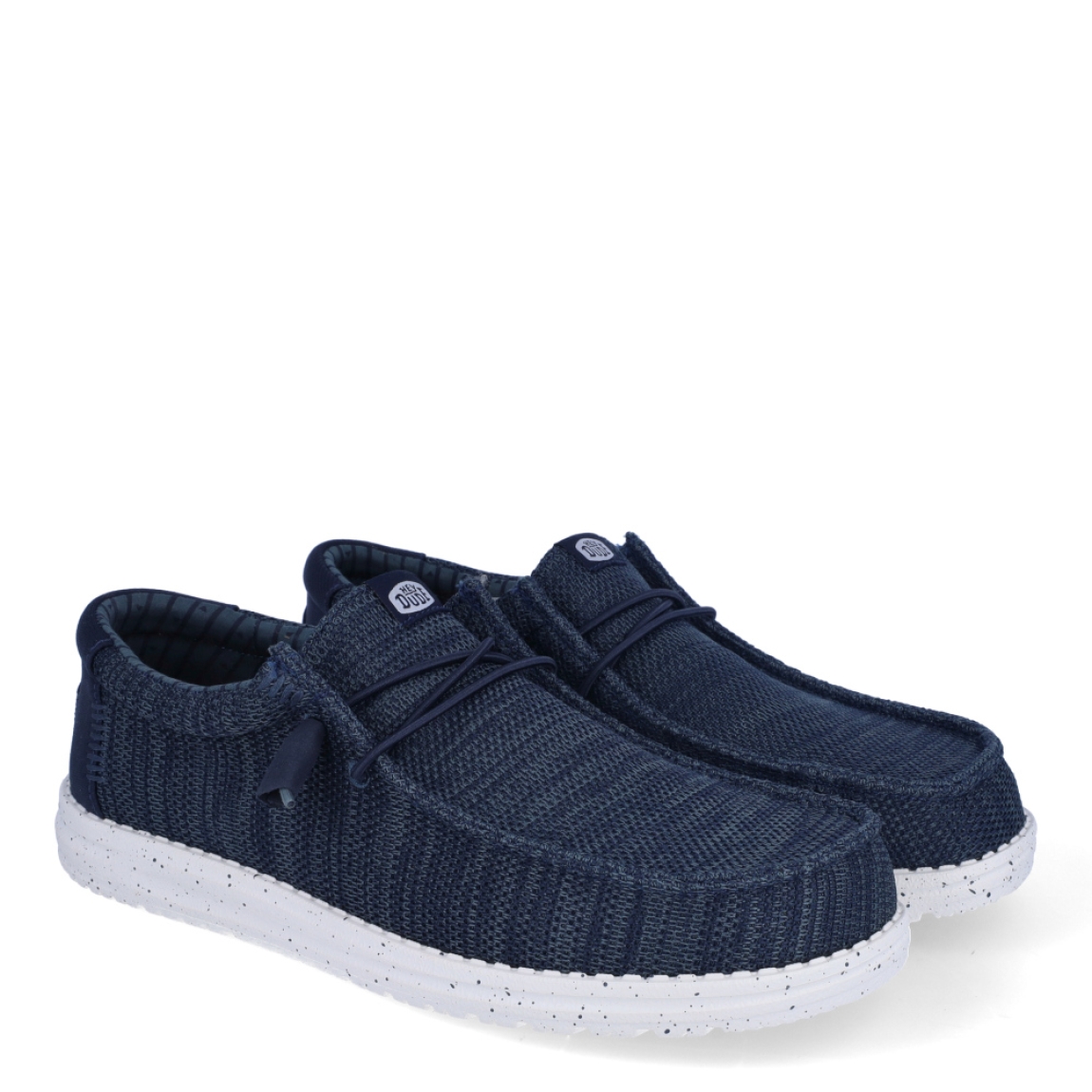 Náuticos de la marca Hey Dude, modelo WALLY STRECH. Exterior de los náuticos en tela color azul. Interior de los náuticos en tela color azul y plantilla acolchada y extraíble. Cierre de los náuticos Hey Dude con cordones elásticos y suela plana de goma. Estos náuticos Hey Dude WALLY STRECH, son el complemento perfecto para esta temporada, los podrás lucir con la máxima comodidad posible.