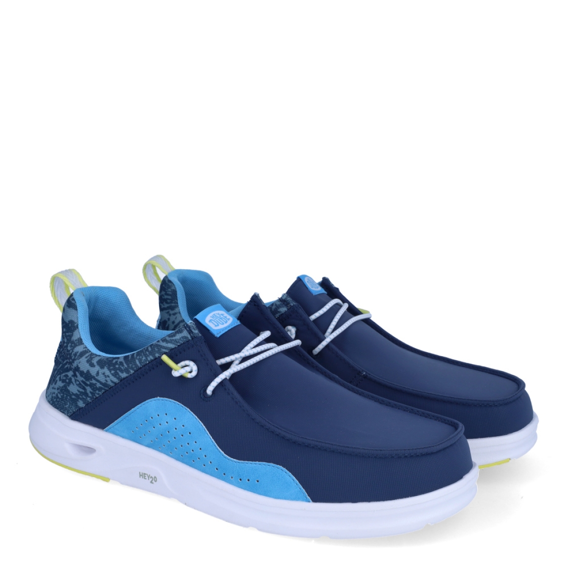 Náuticos de la marca Hey Dude, modelo WALLY HEY20. Exterior de los náuticos en tela color azul con detalles en celeste. Interior de los náuticos en tela con estampado azul y plantilla acolchada y extraíble. Cierre de los náuticos Hey Dude con cordones elásticos y suela plana de goma. Estos náuticos Hey Dude WALLY HEY20, son el complemento perfecto para esta temporada, los podrás lucir con la máxima comodidad posible.