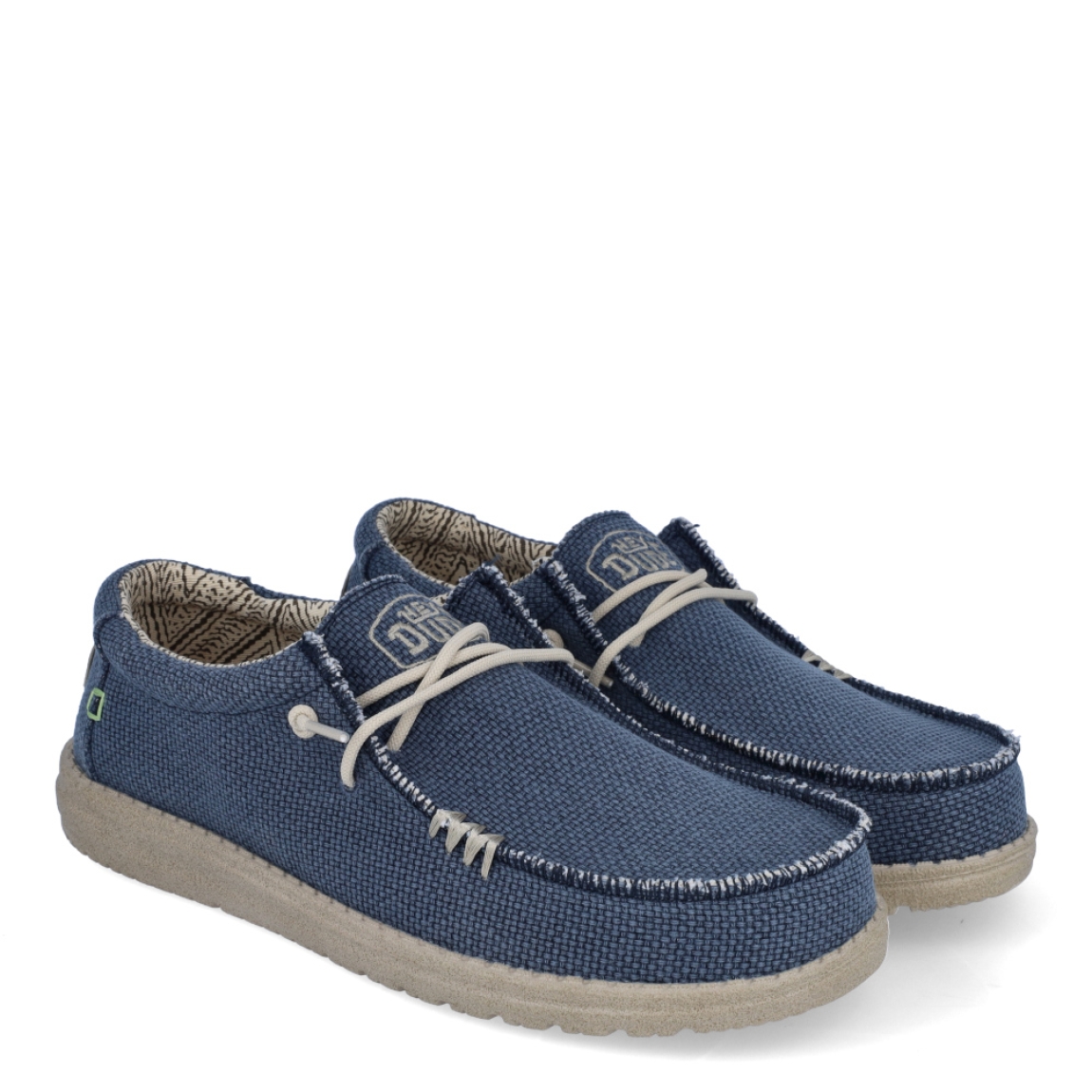 Náuticos de la marca Hey Dude, modelo WALLY BRAIDED. Exterior de los náuticos en tela color azul. Interior de los náuticos en tela con estampado gris y plantilla acolchada y extraíble. Cierre de los náuticos Hey Dude con cordones elásticos y suela plana de goma. Estos náuticos Hey Dude WALLY BRAIDED, son el complemento perfecto para esta temporada, los podrás lucir con la máxima comodidad posible.