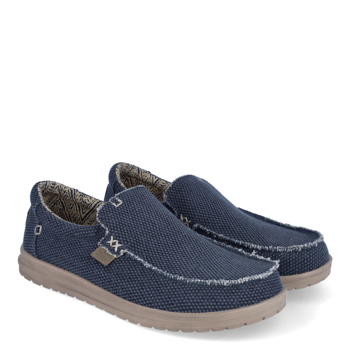 Naútico clásico de la marca Hey Dude, modelo Mikka Braided. Exterior del naútico de tela de color azul, hecha con algodón orgánico. Interior del naútico de tela. Naútico con suela ultraligera y flexible. Naútico con plantilla extraíble que absorbe la humedad y són ergonómicas. Dispone de un cordón elástico interior que facilita el ajuste del zapato. El naútico Mikka Braided es un clásico de hombre con un diseño ecológico, elaborado con algodón orgánico ultra resistente y transpirable. Además, estos naúticos Hey Dude han sido fabricados sin productos de origen animal.
