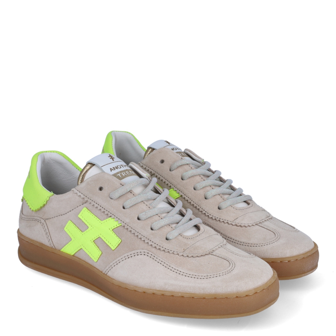 Deportivas de la marca Another Trend, modelo A32. Exterior en ante color beig con detalle del logo en color verde neón, al igual que la parte del talón. Interior en piel color blanco. Cierre de las depoerivas Another Trend con cordones y suela de goma plana. Estas deportivas Another Trend A32 son, sin duda, un complemento ideal para tus looks urbanos, con estilo y comodidad.