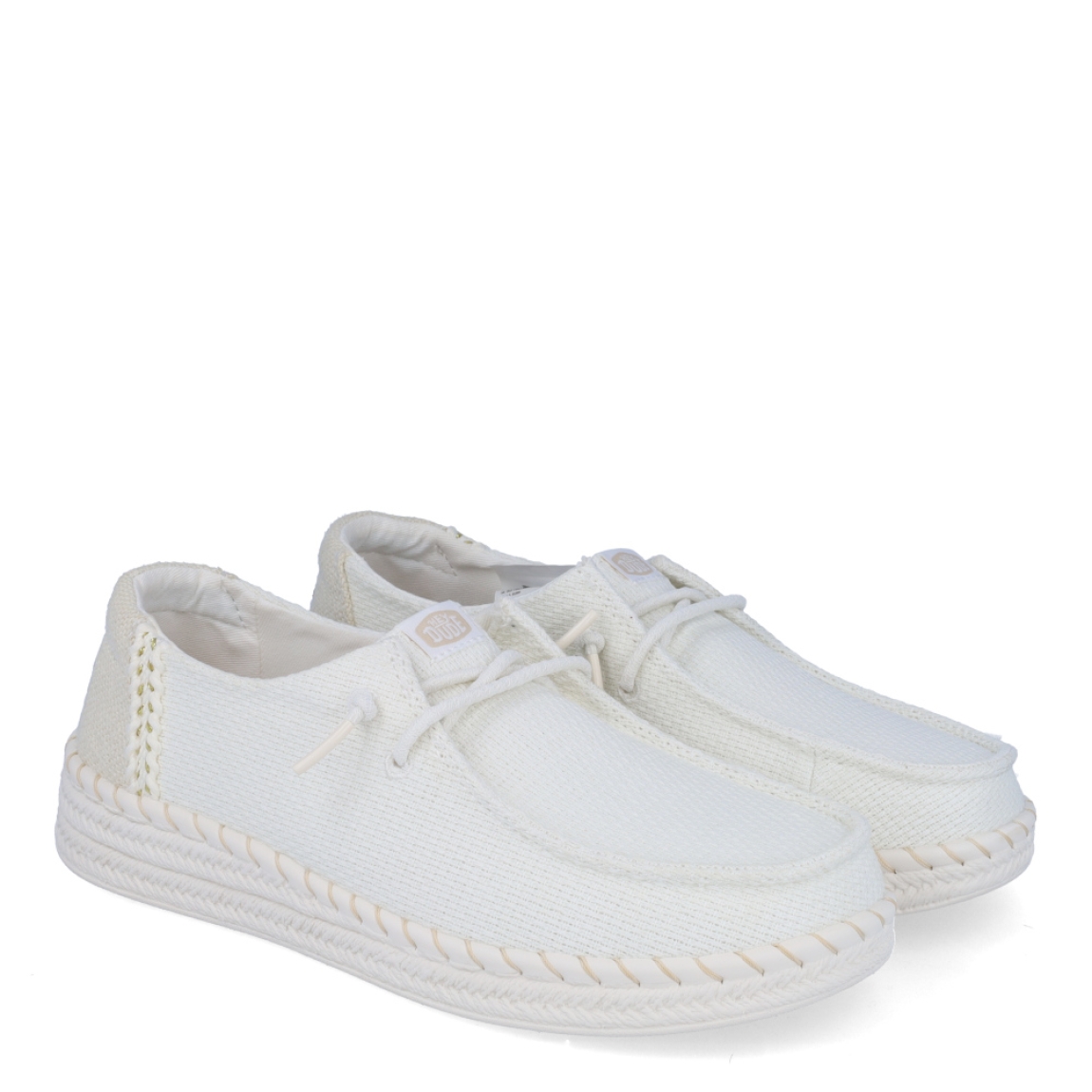 Náuticos transpirables de la marca Hey Dude, modelo WENDY ESPADRILE. Exterior de los áuticos en textil color blanco. Interior en textil color blanco. Cierre de los náuticos Hey Dude con cordón elástico blanco. Naúticos con suela plana. Estos náuticos Hey Dude WENDY ESPADRILE son el complemento clásico que necesitas esta temporada. No te puede faltar en tu armario.