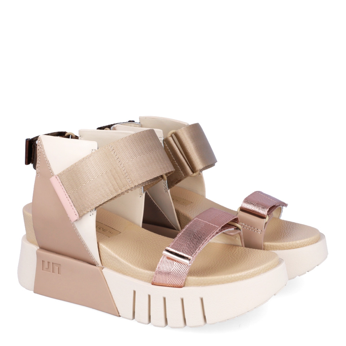 Sandalias de la marca United Nude, modelo Delta Run. Exterior de las sandalias en piel color beig. Interior de las sandalias de piel. Cierre de las sandalias con triple velcro de colores blanco, negro y dorado en el talón, pala y empeine respectivamente. Sandalias United Nude con cuña de 3cm de altura. Estas sandalias United Nude Delta Run tienen el estilo, diseño y comodidad que necesitas para destacarte en tu día a día.