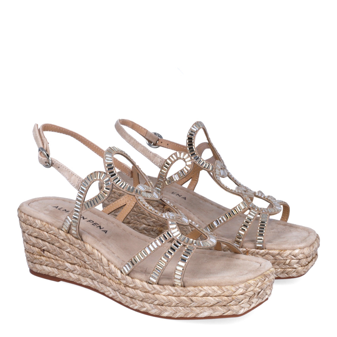 Sandalias de la marca Alma en Pena, modelo IVETT. Exterior de las sandalias en ante color taupe con tiras brillantes en formas de argollas. Interior de las sandalias en ante color taupe. Cierre de las sandalias Alma en Pena con hebilla y cuña de 6cm de altura. Estas sandalias Alma en Pena IVETT tienen el diseño que necesitas para destacar tus looks con elegancia y comodidad. No puede faltar en el armario.