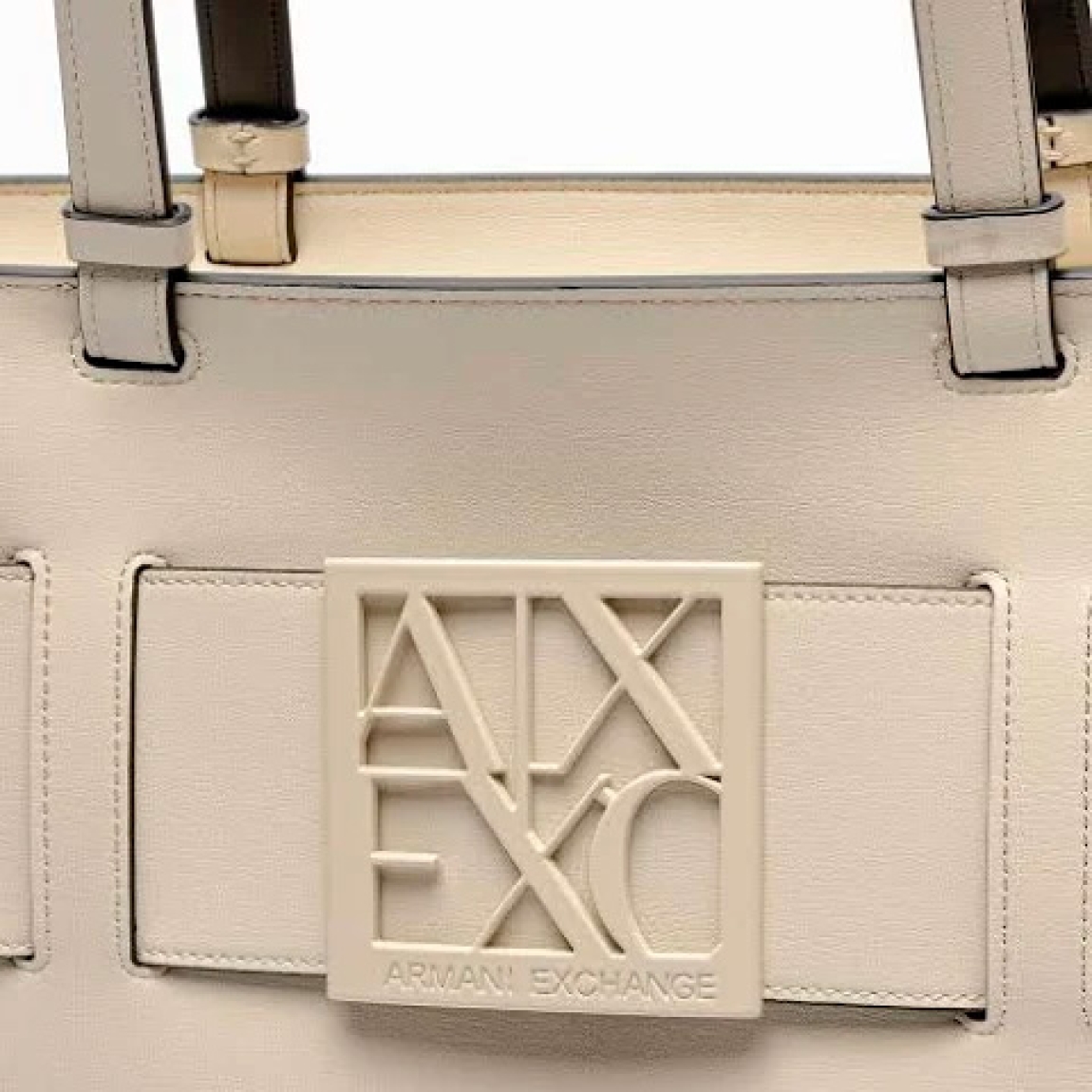 Bolso de la marca Armani Exchange, modelo NILA. Bolso shopper elaborado en piel color beig con logotipo de la marca en parte frontal. Interior sin forro con amplio espacio. Cierre con cremallera y doble asa. Medidas del bolso: alto 26cm y ancho 38cm. Este bolso Armani Exchange NILA es un complemento ideal para combinar y resaltar tus looks de temporada.