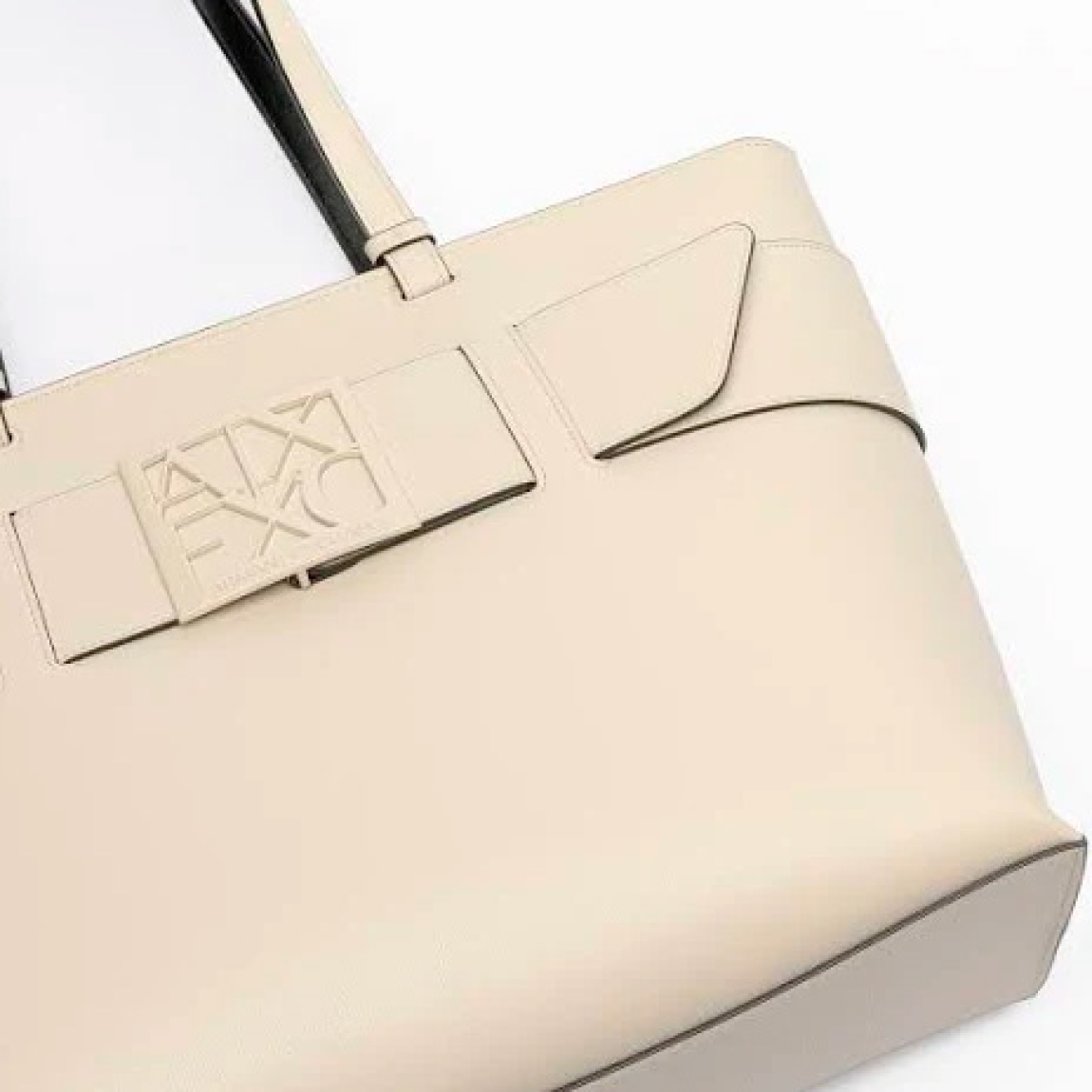Bolso de la marca Armani Exchange, modelo NILA. Bolso shopper elaborado en piel color beig con logotipo de la marca en parte frontal. Interior sin forro con amplio espacio. Cierre con cremallera y doble asa. Medidas del bolso: alto 26cm y ancho 38cm. Este bolso Armani Exchange NILA es un complemento ideal para combinar y resaltar tus looks de temporada.