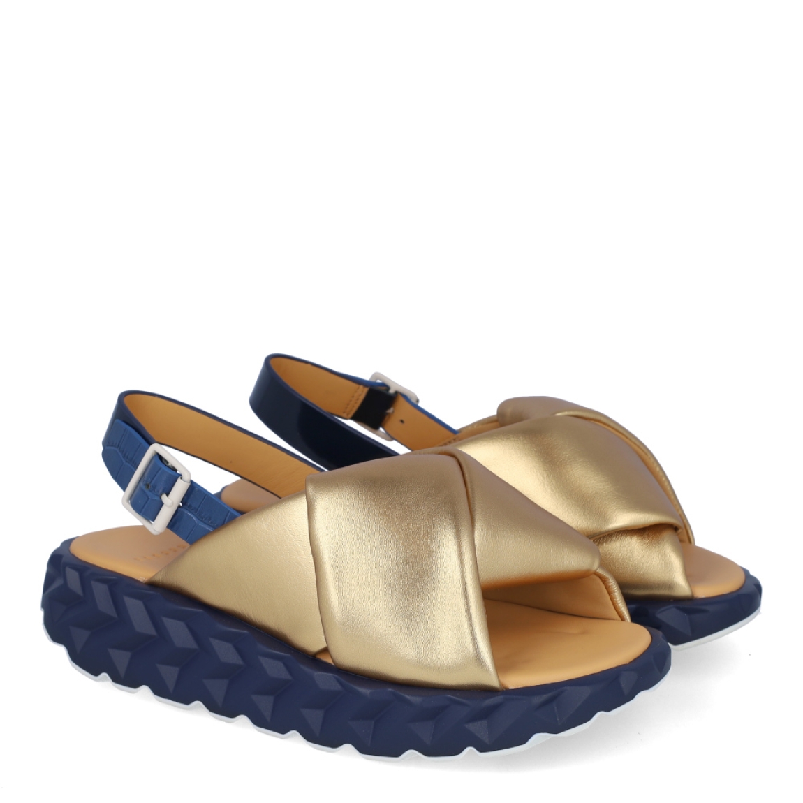 Sandalias de la marca 4CCCCEES, modelo JABARA. Exterior de las sandalias en piel color oro con pala cruzada. Interior de las sandalias en piel color camel. Cierre con hebilla en el tobillo color negro. Sandalias 4CCCCEES con cuña de 3cm de altura con diseño ondulado color negro. Estas sandalias 4CCCCEES JABARA tiene el diseño perfecto entre originalidad y ligereza que te acompañará en tu día a día en esta temporada.