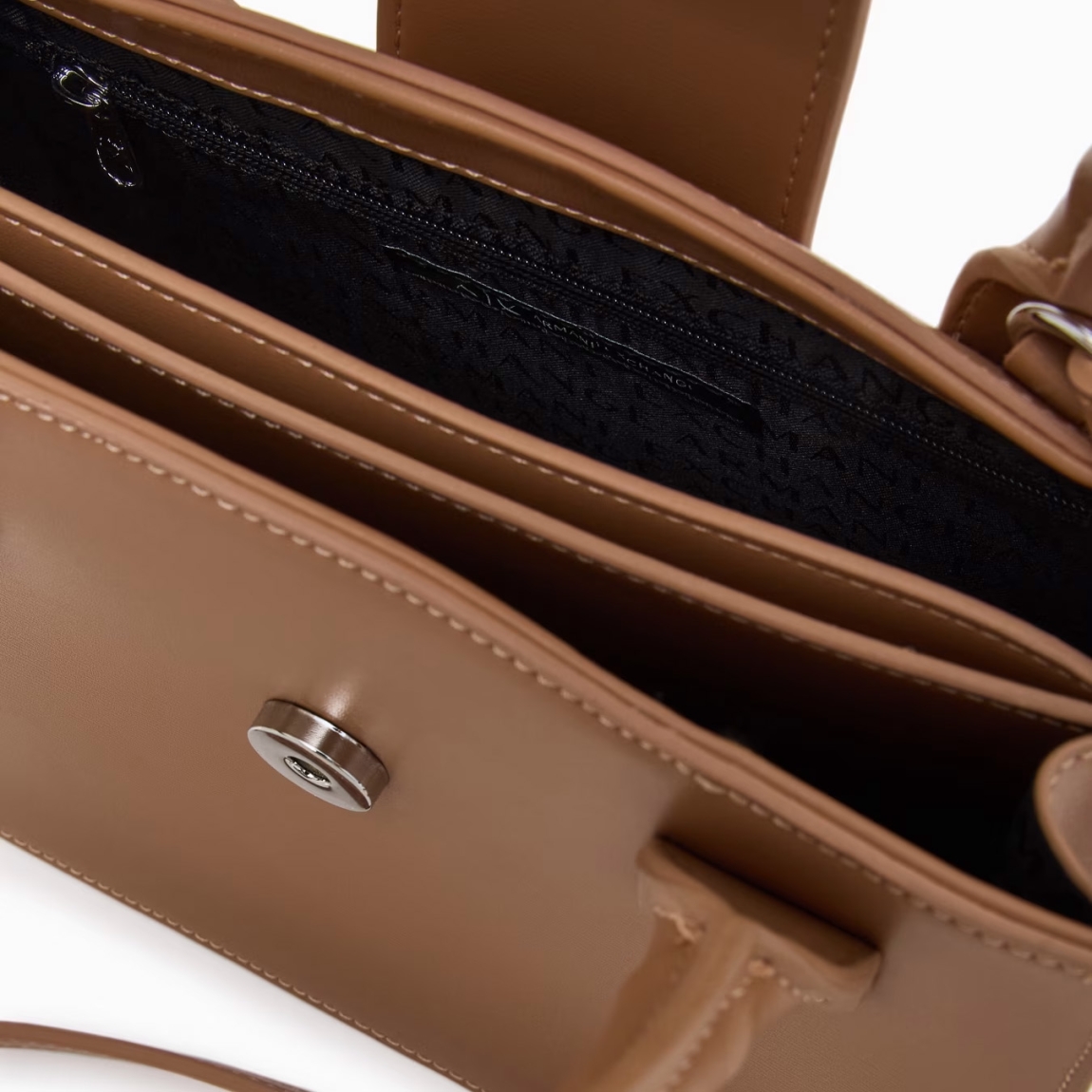 Bolso de la marca Armani Exchange, modelo ASV. Bolso de mano elaborado en piel color camel con forma de trapecio, elegante y sofisticado. El diseño estructurado le da un aspecto moderno y versátil, perfecto para cualquier ocasión. La correa de hombro extraíble te permite transformarlo fácilmente en un bolso de mano o de hombro. Cierre con botón. Medidas: alto 15cm y ancho 21cm. Este bolso Armani Exchange es todo lo que necesitas esta temporada!