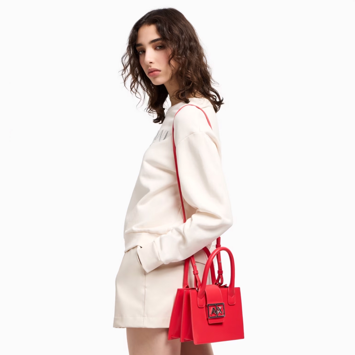 Bolso de la marca Armani Exchange, modelo ASV. Bolso de mano elaborado en piel color rojo con forma de trapecio, elegante y sofisticado. El diseño estructurado le da un aspecto moderno y versátil, perfecto para cualquier ocasión. La correa de hombro extraíble te permite transformarlo fácilmente en un bolso de mano o de hombro. Cierre con botón. Medidas: alto 15cm y ancho 21cm. Este bolso Armani Exchange es todo lo que necesitas esta temporada!