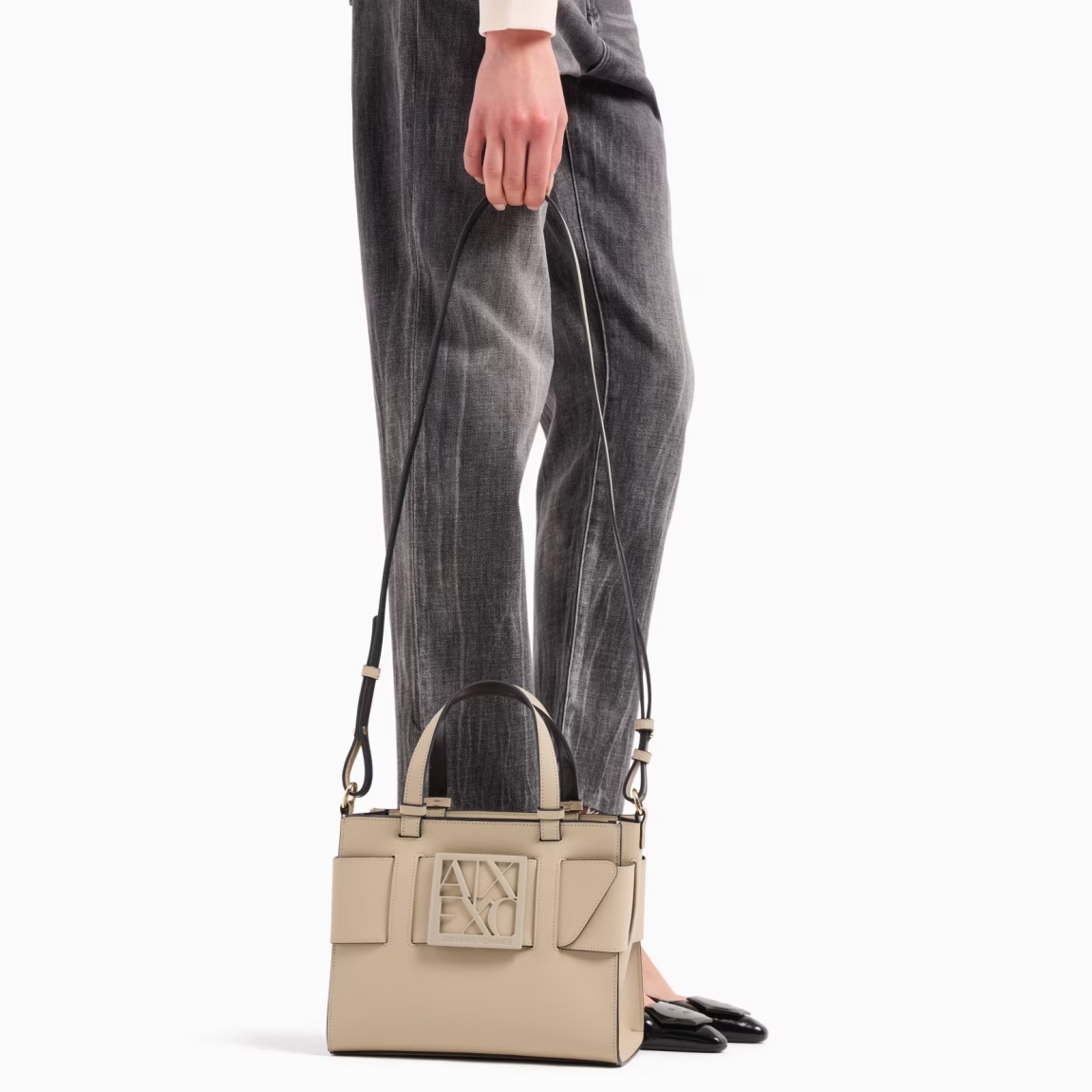 Bolso de la marca Armani Exchange, modelo YSA. Bolso elaborado en piel color beig. Este es un best seller que se renueva cada temporada, perfecto desde todos los puntos de vista y siempre cool: el bolso tote mediano con bandolera y banda con hebilla con logo personalizado es el accesorio que no puede faltar en el look.Material externo: 100% poliuretano; tejido intermedio: 100% poliéster; material interno: 100% poliuretano. Cierre con cremallera. Medidas: alto 18cm y ancho 24cm.