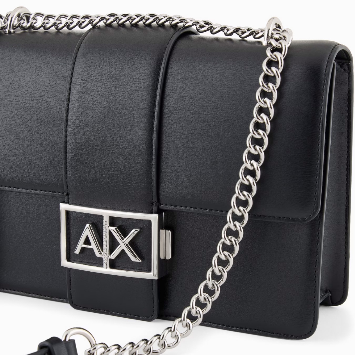 Este bolso de hombro de la marca Armani Exchange, modelo AVA, está elaborado de piel sintética color negro. E un accesorio elegante y sofisticado, perfecto para cualquier ocasión. La correa de cadena para el hombro añade un toque de clase, mientras que el logotipo de metal en la parte delantera aporta un detalle distintivo y moderno. El cierre a presión garantiza seguridad y comodidad, manteniendo el contenido seguro. Compacto pero espacioso, este bolso es ideal para una apariencia elegante y versátil, combinando funcionalidad y estilo en un diseño refinado. Un artículo imprescindible para cualquier mujer que busque elegancia. Medidas: alto 16cm y acho 25cm.