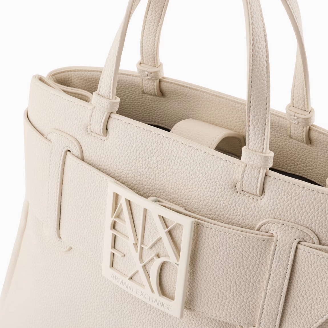 Bolso de mano de la marca Armani Exchange, modelo SOPHI. Elaborado en piel sintética color blanco, elegante y práctico, ideal para cualquier ocasión. El detalle del logotipo tonal en la parte delantera añade un toque sutil de sofisticación. El cierre magnético garantiza seguridad y facilidad de uso, mientras que las dos asas ofrecen un agarre cómodo para un transporte versátil. En el interior, un bolsillo adicional te permite organizar mejor tus artículos personales. Perfecto para el uso diario, este bolso combina estilo, funcionalidad y atención al detalle. Medidas: alto 24cm y ancho 30cm.