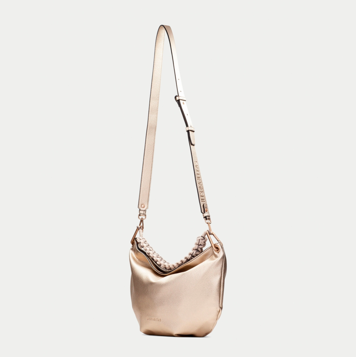 Bolso de hombro de la marca Hispanitas, modelo CAMIL. Exterior en piel color platino con asa corta trenzada que añade un detalle artesanal al diseño. Correa ajustable para llevarlo al hombro o cruzado, permitiendo versatilidad en el uso. Cierre con cremallera permitiendo mayor seguridad. Medidas: 33CM X 26CM X 9CM.