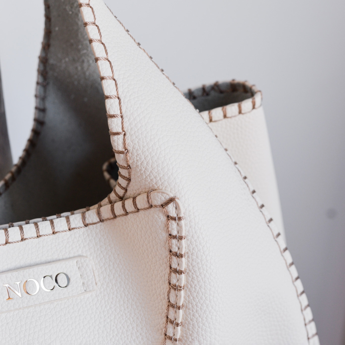 Bolso hobo Noco, modelo SHARAM. Elaborado de piel vegana color blanco. Este bolso es una pieza única que combina estilo y sostenibilidad. Su formato hobo se distingue por su trabajo de diseño original, aportando una forma sofisticada y funcional. El material de piel vegana tiene un acabado que imita a la perfección la piel real, con un suave interior similar al pelo característico de la piel auténtica, brindando una textura premium. Cierre con boton. Medidas alto 21cm y ancho 29cm.