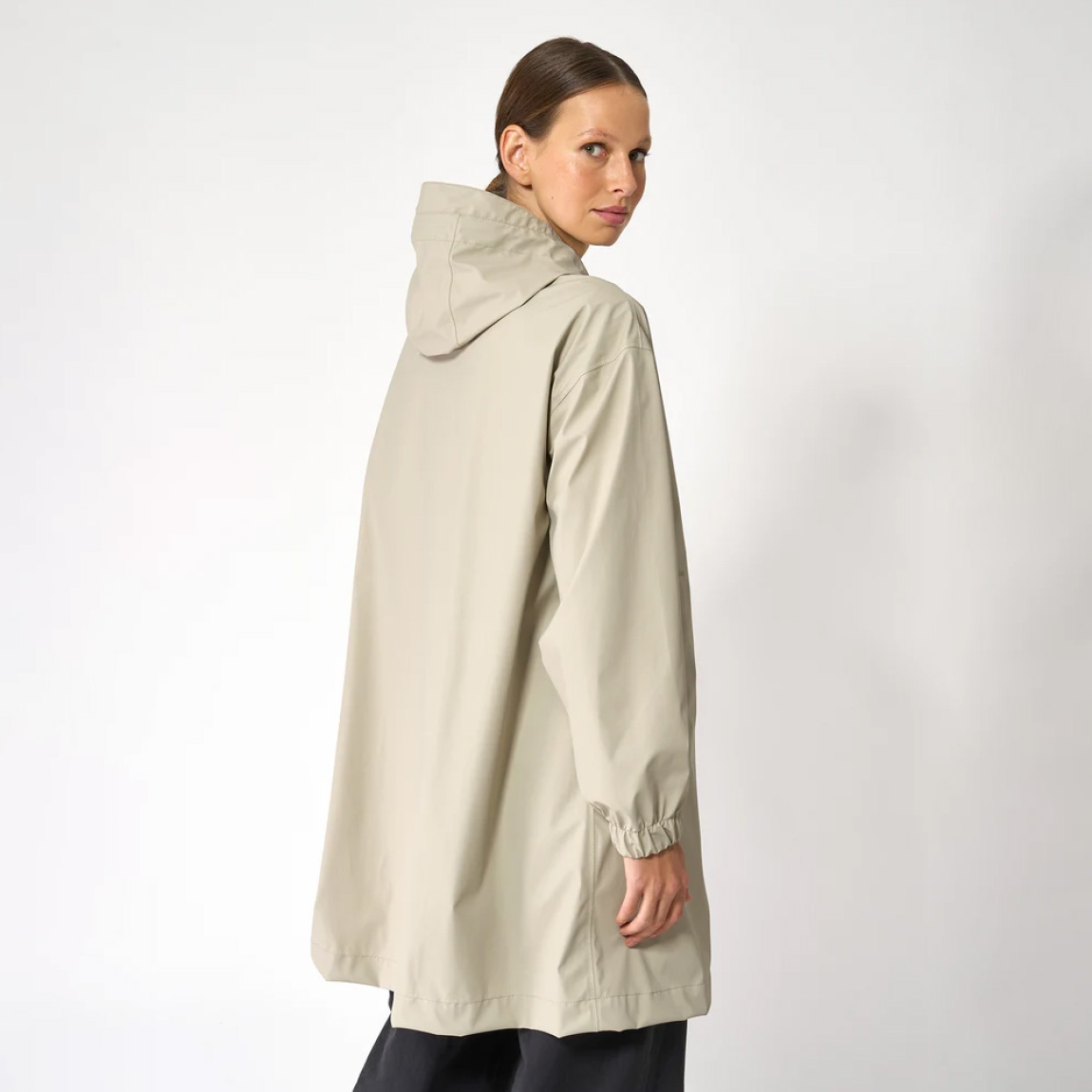 Chaqueta impermeable de la marca Tanta, modelo Mis. Es un chubasquero de corte holgado y diseño siempre contemporáneo 100% impermeable. Está confeccionada con un tejido ligero de PU color beig y cuenta con todas las costuras selladas para una protección superior. Los detalles de la prenda incluyen botones a presión, una capucha con visera incorporada y bolsillos con ribetes. Ideal para esta temporada!