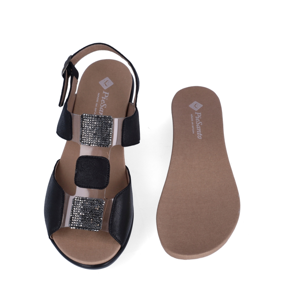 Sandalias de la marca PieSanto, modelo NIKITA. Exterior de las sandalias en piel color negro con detalle de brillantes en la pala. Interior de las sandalias en piel color marrón, con plantilla acolchada y extraíble para máxima comodidad. Cierre de las sandalias PieSanto con hebilla en el tobillo y cuña de 4cm de altura. Estas sandalias PieSanto NIKITA son un complemento ligero y perfecto para esta temporada. No te puede faltar en el armario.