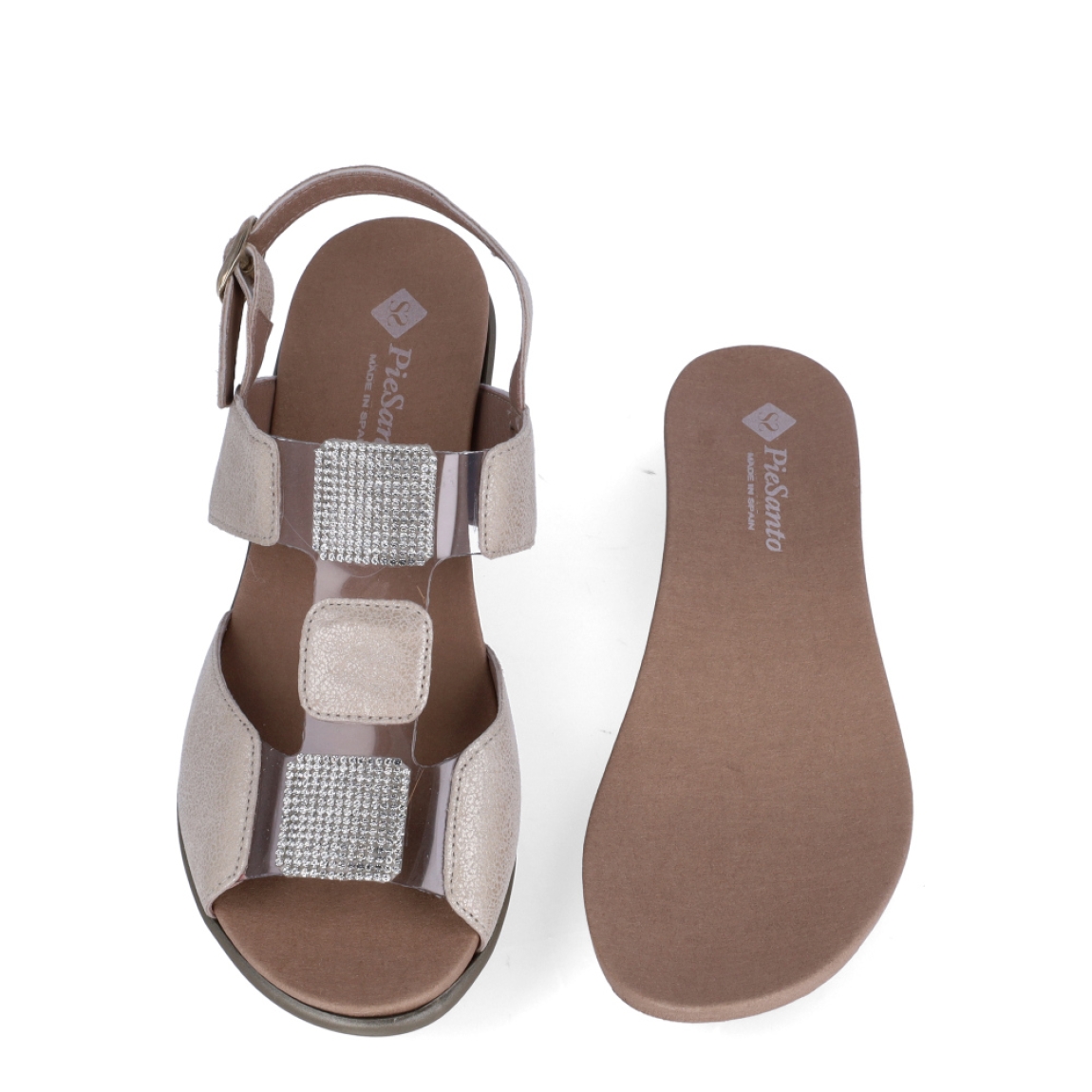 Sandalias de la marca PieSanto, modelo NIKITA. Exterior de las sandalias en piel color beig con detalle de brillantes en la pala. Interior de las sandalias en piel color marrón, con plantilla acolchada y extraíble para máxima comodidad. Cierre de las sandalias PieSanto con hebilla en el tobillo y cuña de 4cm de altura. Estas sandalias PieSanto NIKITA son un complemento ligero y perfecto para esta temporada. No te puede faltar en el armario.