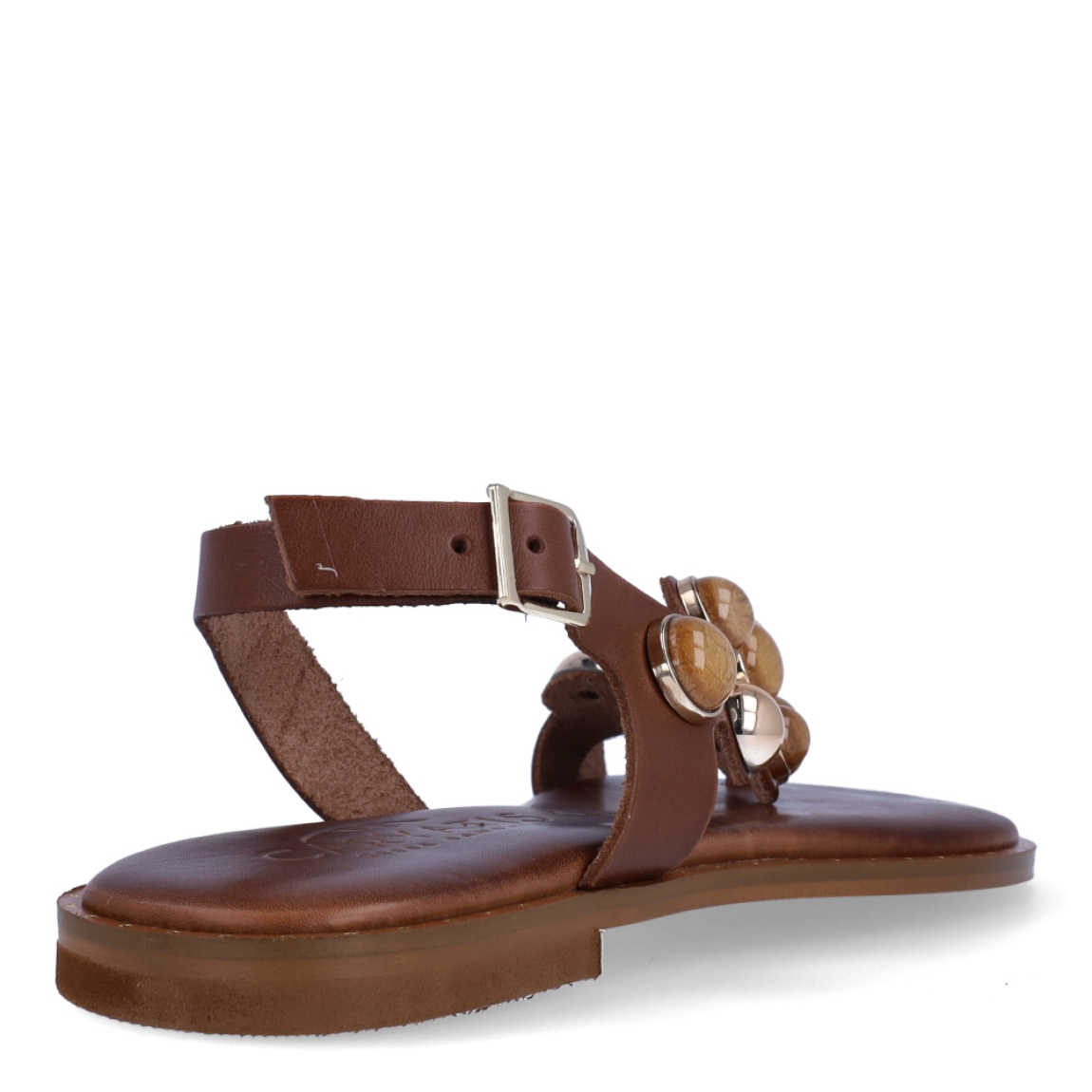 Esclavas de la marca Caryatis, modelo SENDRA. Exterior de las esclavas en piel color marrón con adornos en piedrería. Cierre de las esclavas con hebilla y suela plana. Estas esclavas Caryatis SENDRA es un producto de alta calidad, pensado en la comodidad y elegancia. No puede faltar en tu armario de temporada.