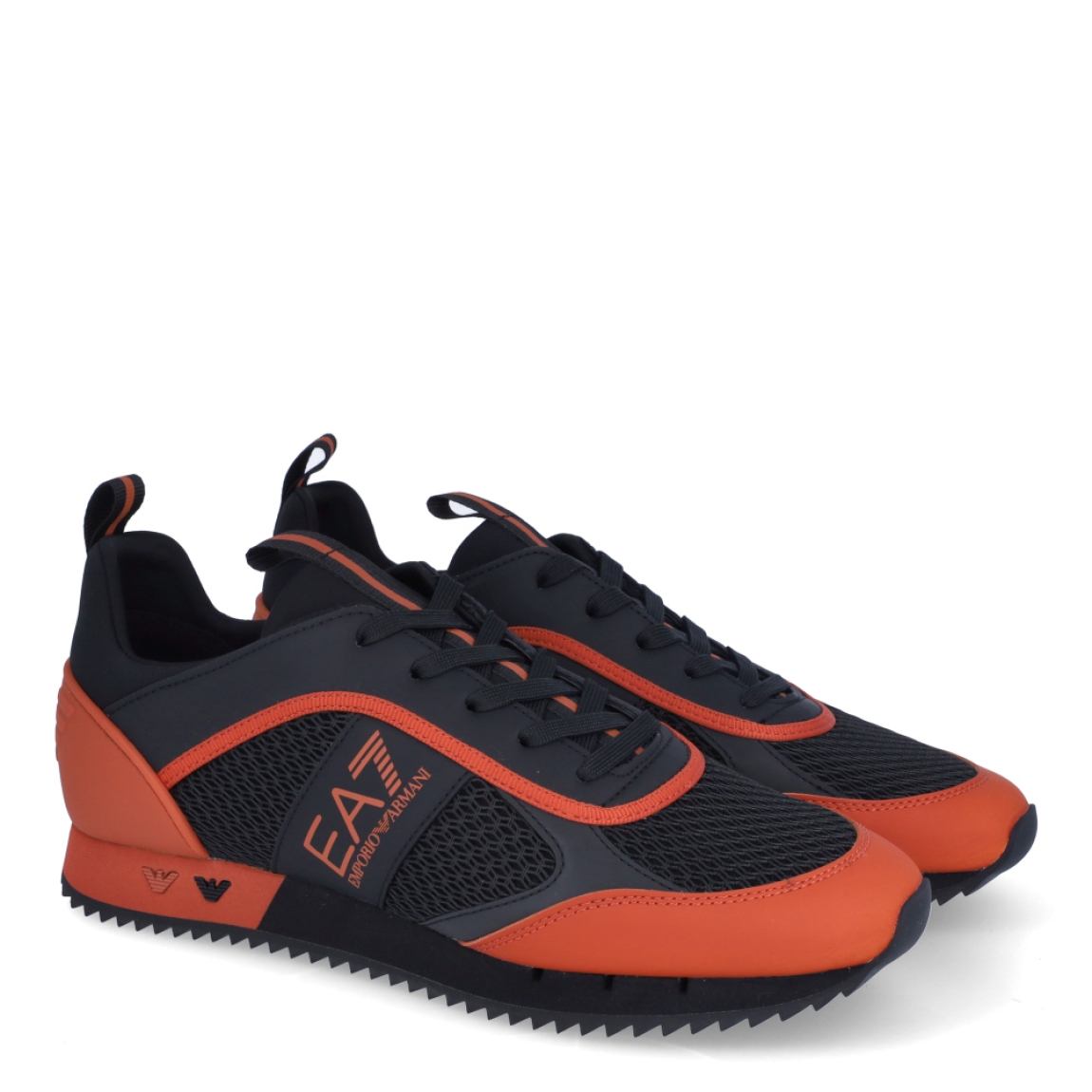 Deportiva de la marca Armani Exchange, modelo X8X. Exterior de la deportiva de piel color negro con naranja. Detalle logotipo lateral en piel de color naranja. Interior de la deportiva de textil de color negro. Cierre de la deportiva con cordones. Deportiva con suela plana de goma. Deportiva con plantilla acolchada. La deportiva X8X de Armani Exchange es una deportiva clásica y cómoda, perfecta para el día a día.